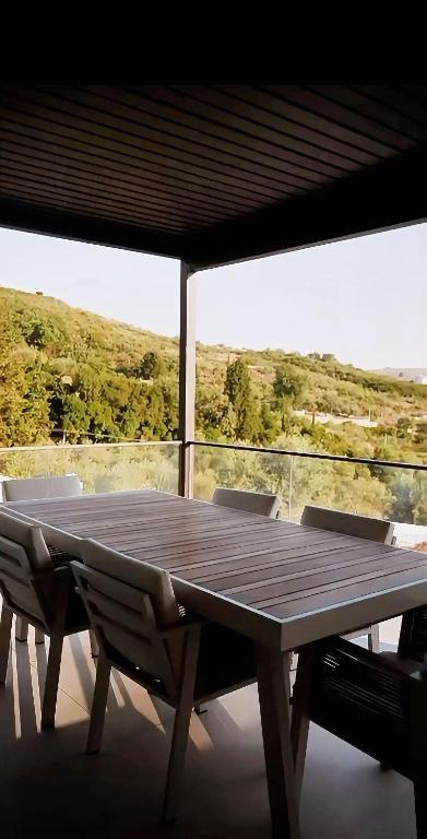 A wooden table and two chairs on a balcony at Vila Luar
