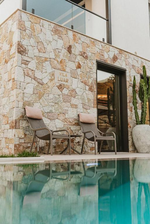 Sun beds beside the private pool at Vila Luar, with the Ionian Sea beyond